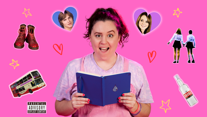 A photo of Beth (a white person with dark hair in a high ponytail, wearing pink dungarees and a lilac tie-dyed t-shirt). Beth is against a pink backdrop, opening a blue diary with a scandalised expression - one eyebrow raised, mouth open in shocked amusement. 